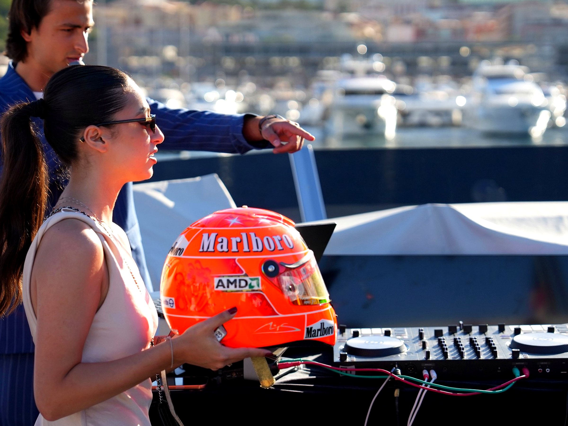 Hostess presenting a signed Michael Schumacher racing helmet to guests aboard the yacht in Monaco