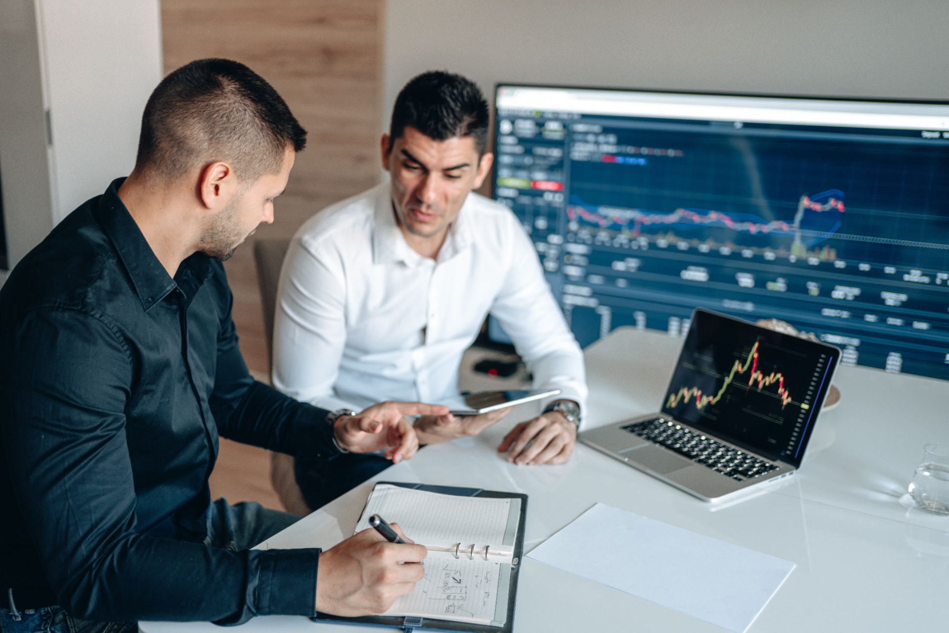Two professionals reviewing market data during an admission meeting