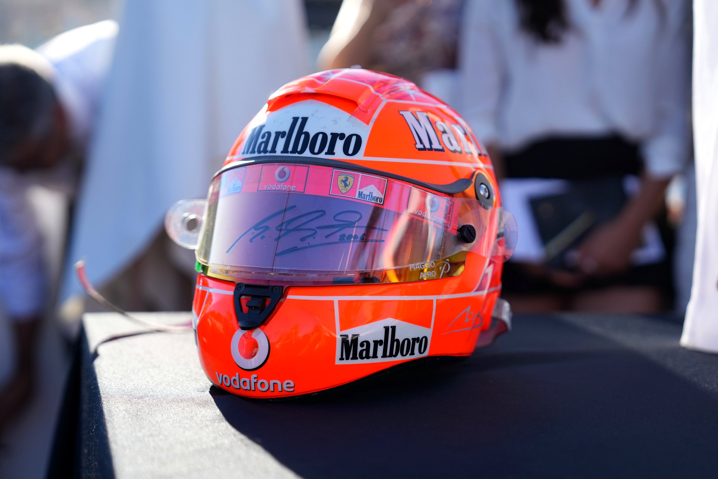 A signed red racing helmet displayed on a table in front of guests at the Altherum launch event